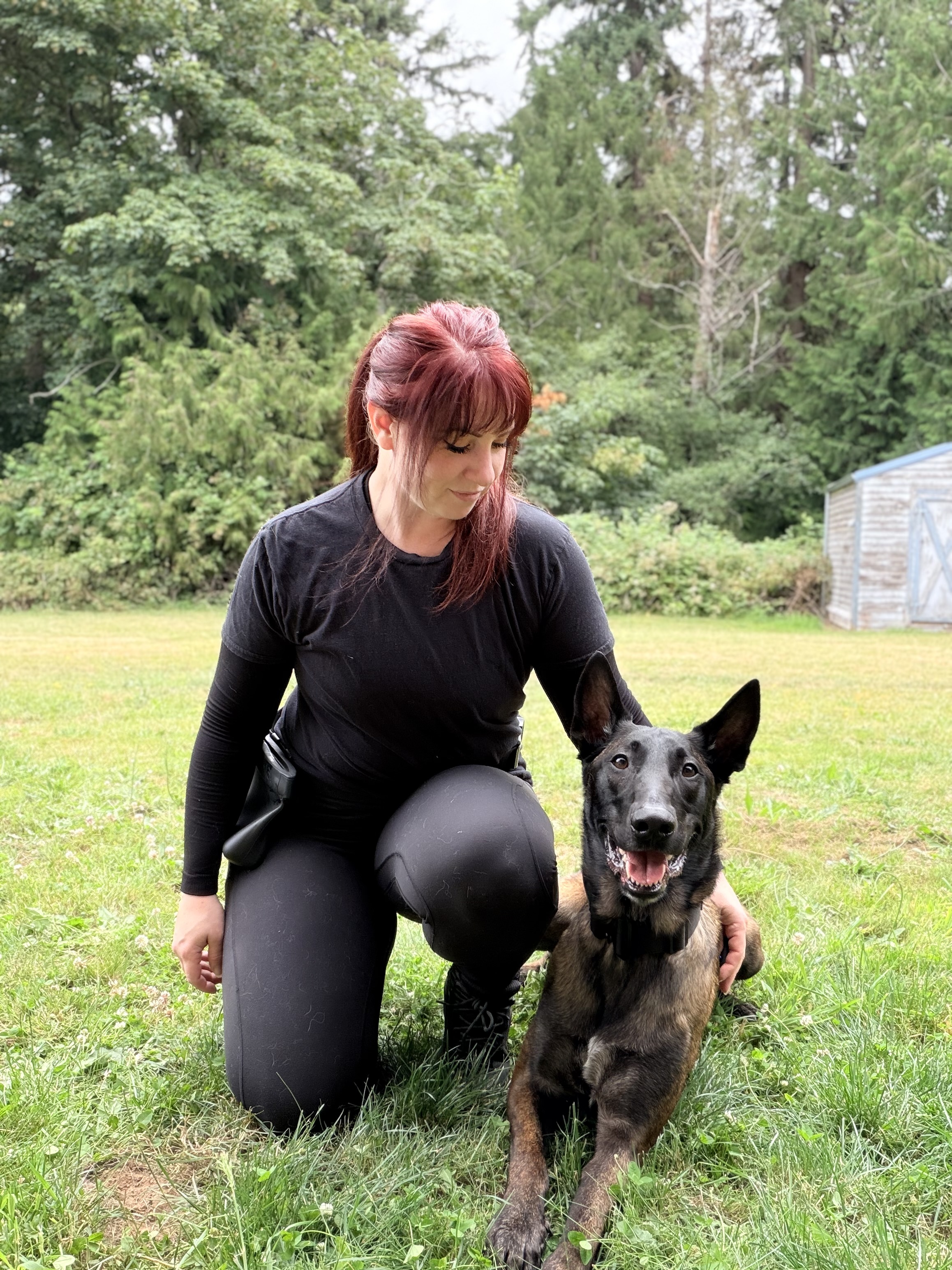 Kylee kneeling with a dog during an in-home training session